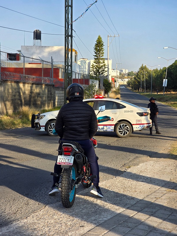 Patrulla de la policía municipal de Puebla bloquea un camino debido al hallazgo de un cadáver en colonia La Joya.