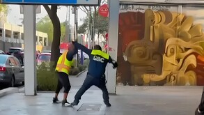Policía de tránsito peleando con un hombre afuera del Metro San Antonio Abad.