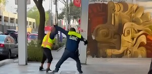 Policía de tránsito peleando con un hombre afuera del Metro San Antonio Abad.