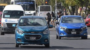 Vehículos conduciendo en una vía de Puebla.
