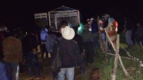 Hombre con sombrero se une a una multitud entre la oscuridad.