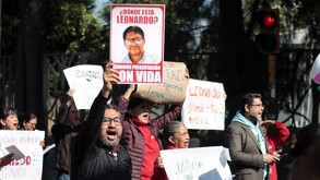 Hombre protesta con la fotografía de Ariel Escobar, docente de la Ibero Puebla desaparecido.
