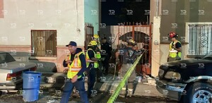 Se observan unas viviendas, y unas personas afuera, hay una cinta amarilla de precaución.