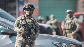 Militar armado aguarda durante un cateo realizado a la calle 46 Poniente en Puebla capital.