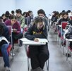 Estudiantes de la UDG en un aula escolar realizando actividad