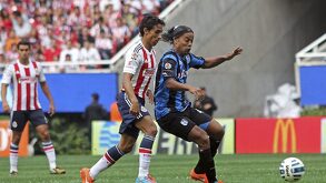 Fernando Arce y Ronaldinho, ex jugadores profesionales durante un partido de Chivas vs Querétaro en el estadio Akron en 2014.