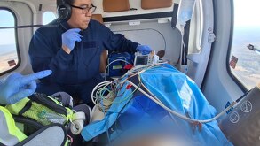 un paramédico traslada a una persona lesionada en ambulancia aérea