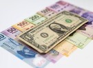 Dólar estadounidense sobre una cama de billetes de pesos mexicanos.