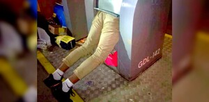 Hombre con medio cuerpo dentro de contenedor de basura y con las piernas hacia afuera en calles de Guadalajara