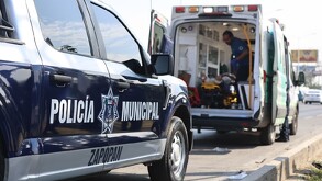 Patrulla de la Policía de Zapopan estacionada detrás de una ambulancia de la Cruz Verde con las puertas abiertas