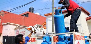 dos hombres trabajan repartiendo tanques de gas lp en puebla