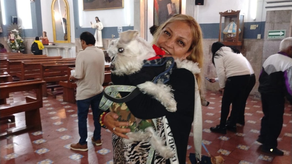 una mujer carga a su perrita en la bendición de las mascotas del día de san antonio abad