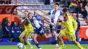 Jugadores de América y Pachuca disputando un balón.
