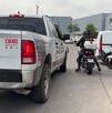 Policías a bordo de motocicletas al lado de una patrulla de la Policía de Tlaquepaque afuera de una plaza comercial