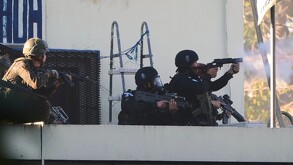 Policías y militares de Guatemala en el techado de una prisión disparando con armas largas