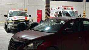 Se observa una ambulancia y unos vehículos estacionados.