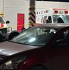Se observa una ambulancia y unos vehículos estacionados.