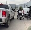 Policías a bordo de motocicletas al lado de una patrulla de la Policía de Tlaquepaque afuera de una plaza comercial