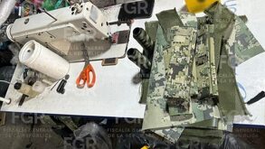 Máquina de coser junto a un chaleco táctico clonado, elaborado de manera artesanal.