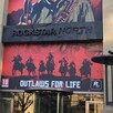 Vista de la fachada principal del edificio de Rockstar North con carteles del videojuego Red Dead Redemption