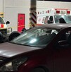 Se observan varios autos estacionados , entre ellos una ambulancia.