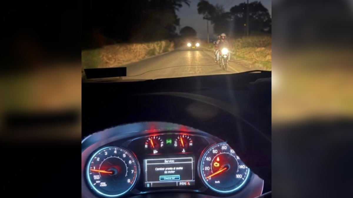 imagen de un auto y una motocicleta en un camino visto desde el parabrisas al interior de un auto