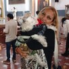 una mujer carga a su perrita en la bendición de las mascotas del día de san antonio abad