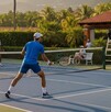 Una pareja de dobles en tenis disputa un partido con juez incluido al atardecer.