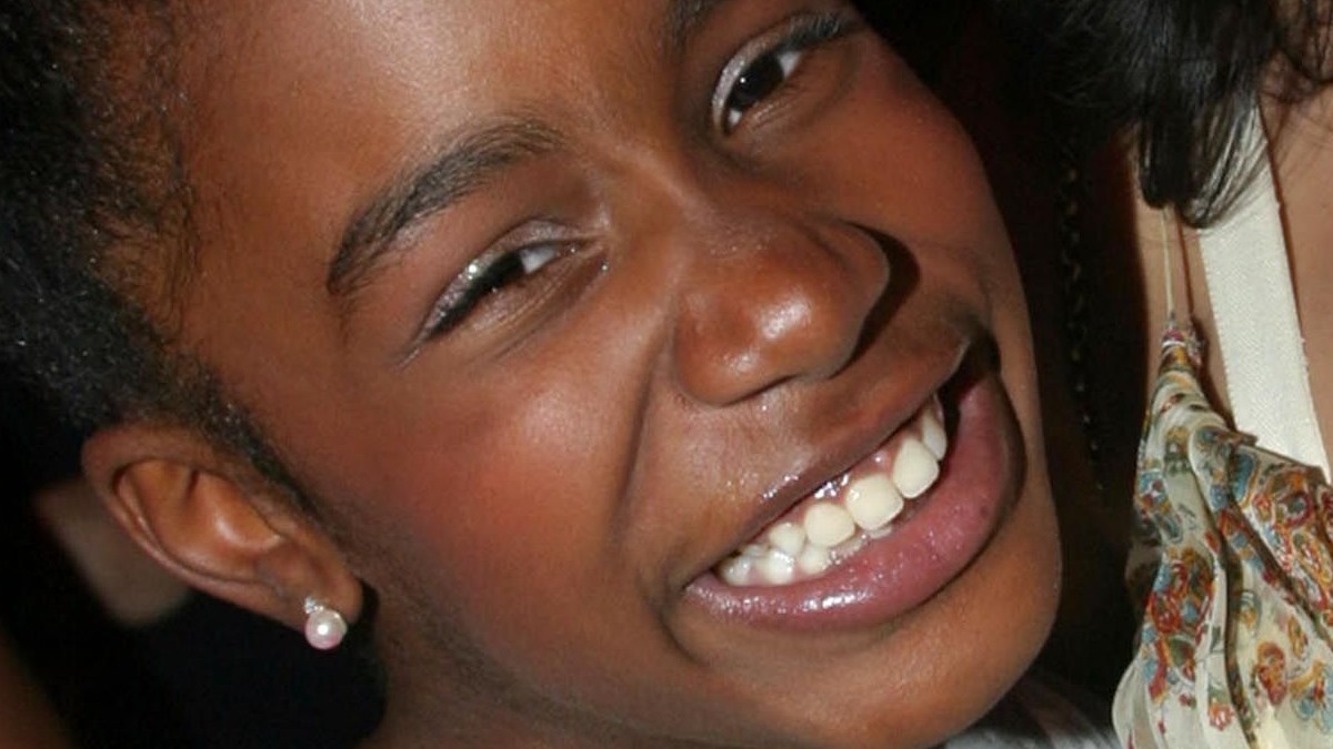 Joven mujer sonriendo a la cámara con aretes redondos en color rosa