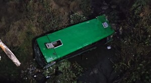 Camión de la ruta 50 color verde visto desde arriba al interior de un barranco en un terreno baldío a un costado de la calle