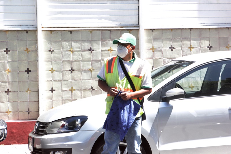 Franelero resguarda un vehículo estacionado en calles de Puebla.