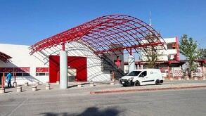 Se observa un edificio blanco con rojo y una cruz de color rojo.