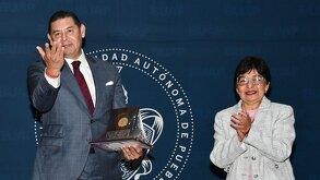 alejandro armenta y lilia cedillo en la entrega de un reconocimiento en la buap