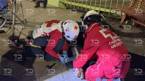 Se observa una persona tirada en el piso, una banca y un hombre con casco.