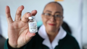 una enfermera sostiene una vacuna contra el sarampión