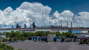 Se observa un edificio color gris con azul y unas letras que dicen Altos Hornos de México.