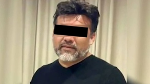 Hombre identificado como Eduardo 'N' viendo de frente con los ojos censurados delante de una cortina beige