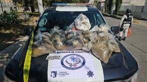 Sobre el cofre de una patrulla de Guadalajara se exhiben bolsas con presunta droga incautada en la Barranca de Huentitán por la Guardia Nacional.