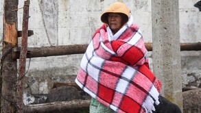 Se observa a una mujer de la tercera edad que está cubierta con cobijas.