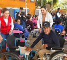Susy Torrecillas y Marisol Rosso junto a un ciudadano en silla de ruedas en la entrega de apoyos invernales.