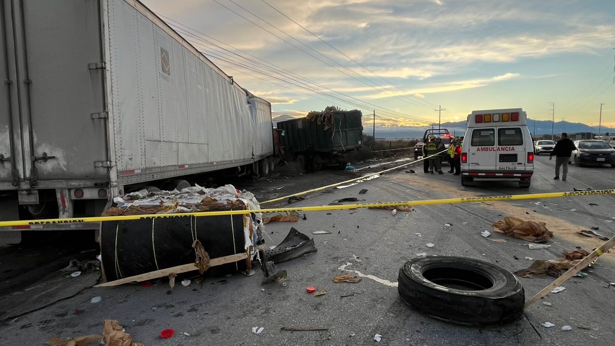 Se observa un tráiler y un carro, una llanta en la carretera y a lo lejos una ambulancia; hay una cinta amarilla de precaución.