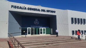 Se observa un edificio color gris con azul que dice Fiscalía General del Estado de Coahuila.