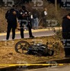 Se observan a unos policías, una cinta amarilla de precaución, una moto y un cuerpo tendido en el suelo.