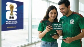 Pareja portando la camiseta de la Selección Nacional mientras observan su celular.