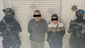 Se observa a dos personas detenidas, con cintilla negra en ojos, están detenidos.