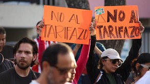Mujeres y hombres alzando carteles naranjas con la leyenda 