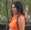 Fotografía de mujer embarazada con un vestido en color naranja.