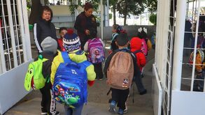 niños con uniforme y mochila entrando a la escuela en puebla
