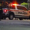 Oficiales y patrulla de la Policía de Tlaquepaque con la sirena encendida detrás de una cinta policiaca amarilla en medio de una calle