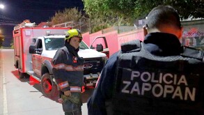 Elemento de Protección Civil frente a un oficial de la Policía de Zapopan visto de espaldas con un camión de bomberos en el fondo